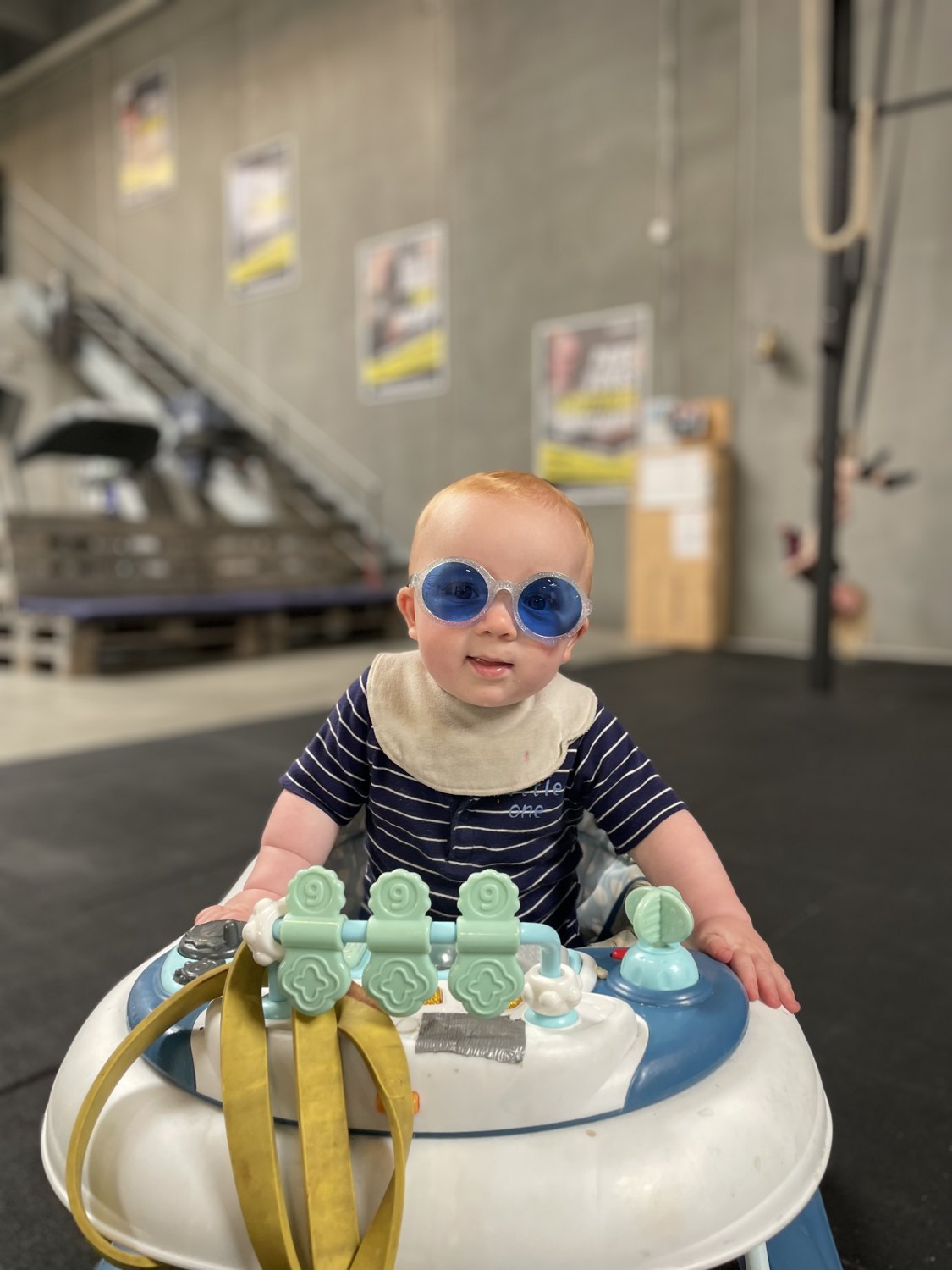 Baby med solbriller i gåstol