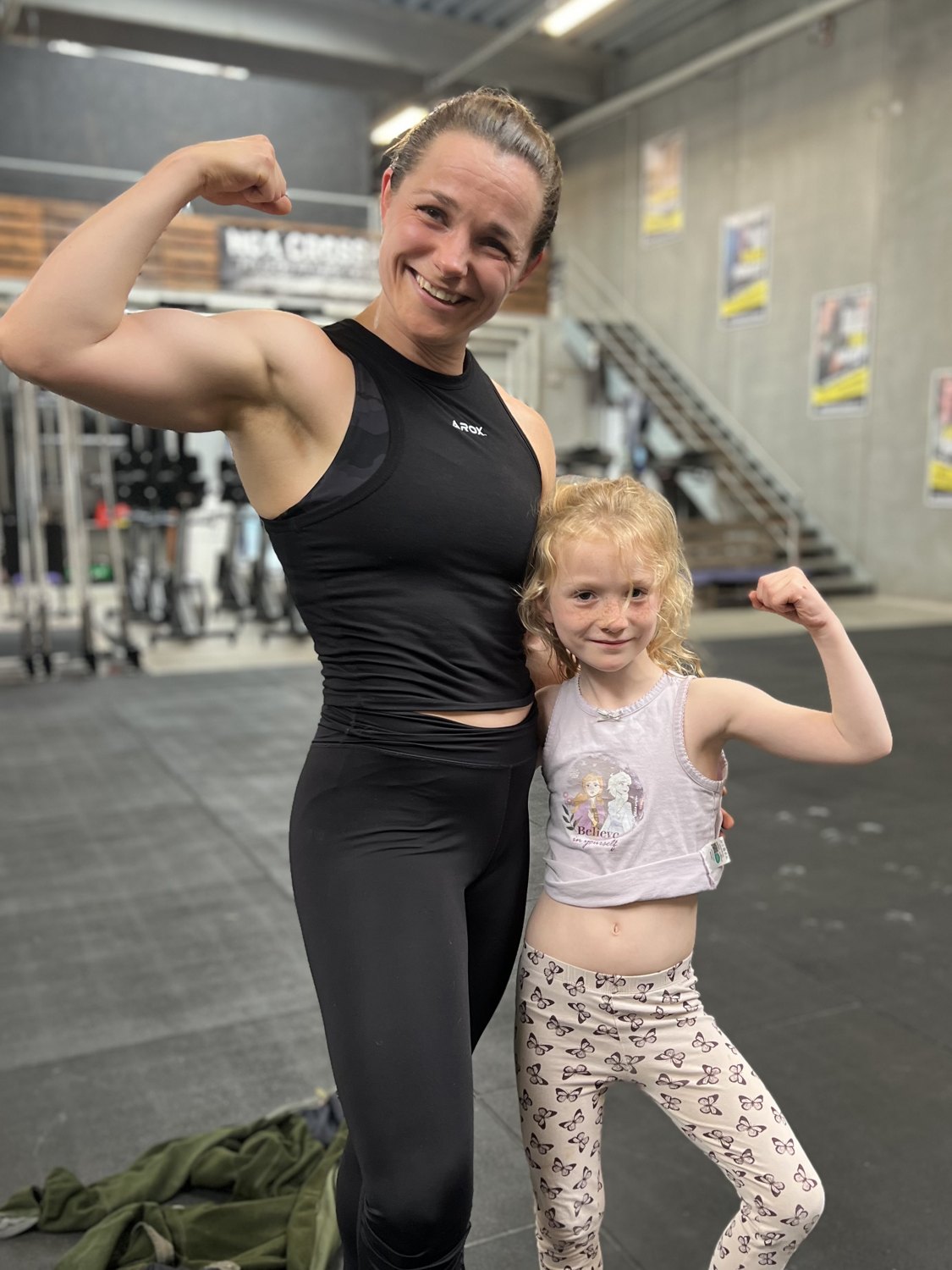 Mor og datter viser muskler i HCA CrossFit
